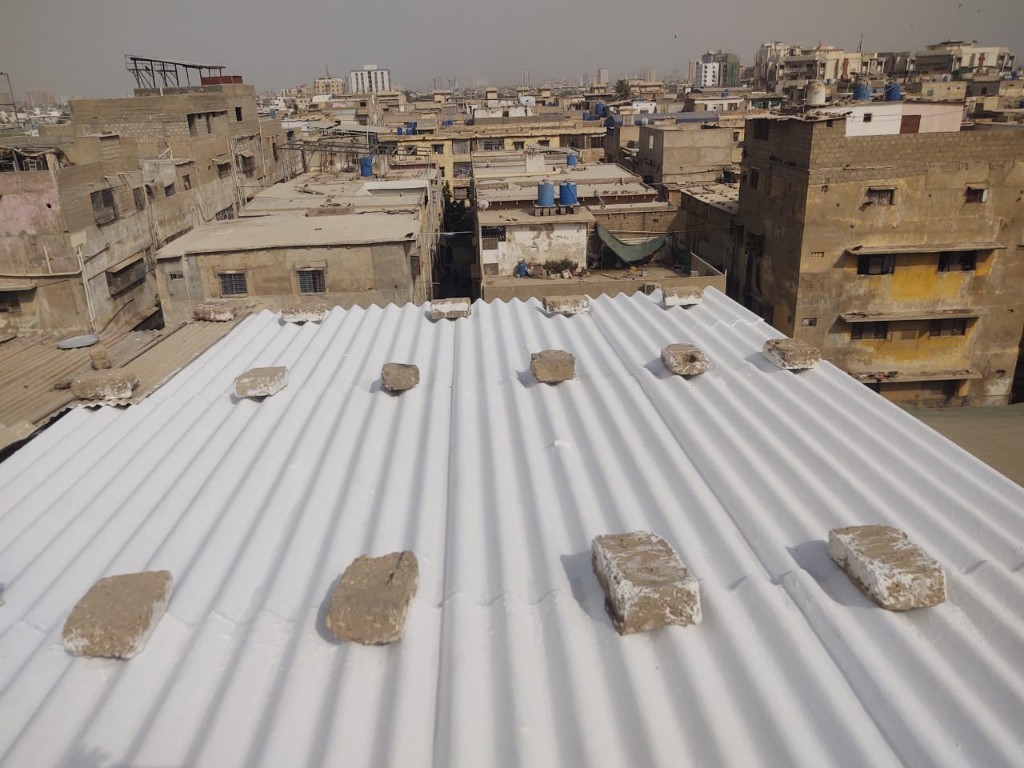 Workers preparing and treating a flat residential rooftop surface